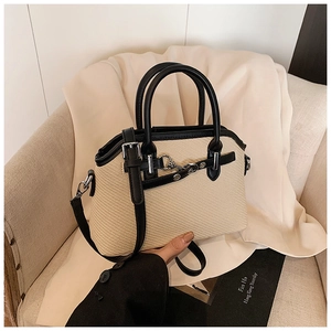 Détail du sac tressé bicolore avec bordure en cuir noir de qualité et fermoir en métal