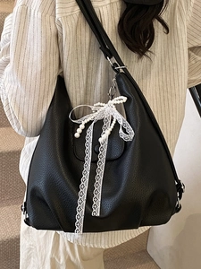 Black litchi grain shoulder tote bag with lace pearl bow charm on model back