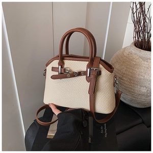 Vue détaillée du sac à main bicolore en paille et cuir avec boucle argentée élégante