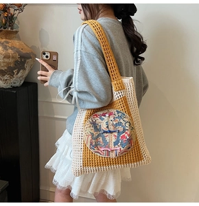Detail of hand-woven tote bag with dragon embroidery and yellow patchwork design