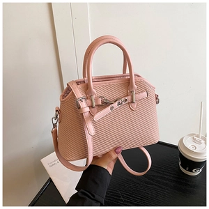 Sac à main tissé rose avec poignées en cuir et boucles métalliques décoratives
