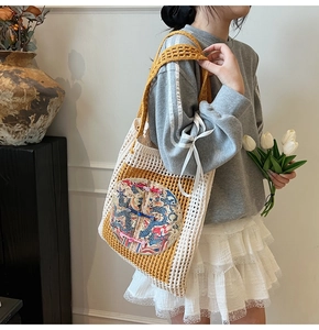 Detail of hand-crocheted tote bag featuring twin dragon embroidery and Chinese knot buttons