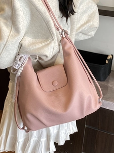 Pink PU leather tote bag with pearl lace bow charm shown on model in a cozy interior