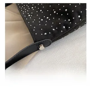 Detail of premium silver rivets on black suede handbag with leather strap and metal studs