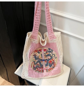 Close-up of crochet tote bag featuring intricate dragon embroidery and Chinese knots