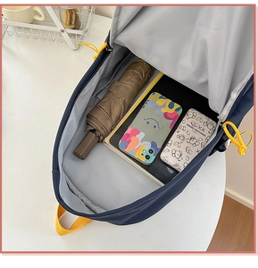 Detail view of large storage compartment in navy nylon backpack with contrast drawstring