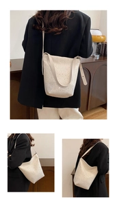 Detail of high-quality rhinestone bucket bag with leather strap on a black blazer