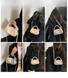 Detail showing pleated cloud handbag in cream white and metallic silver on a model