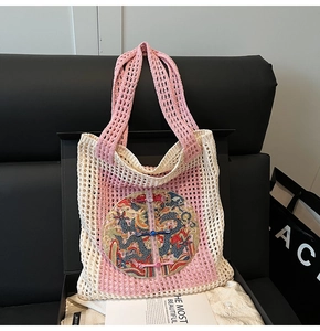 Detail of pink and beige knitted tote bag with dragon embroidery and Chinese button closure