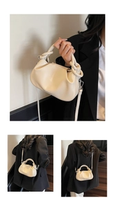 Detail view of cream ruched cloud bag with knotted handle and adjustable leather strap