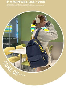 Close-up of minimalist navy blue student backpack featuring bold yellow FU XIAO print