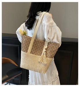 Détail du sac cabas tissé à la main avec texture bicolore et décoration de pompons