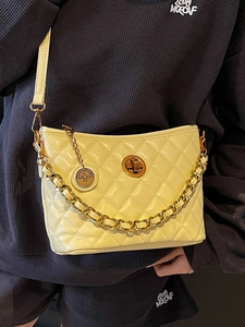 Quilted yellow bucket bag with gold chain and crossbody strap in elegant shiny finish
