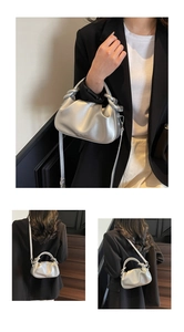 Close-up of metallic silver pleated cloud bag featuring a unique knotted handle design