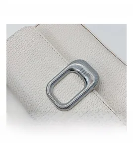 Close-up of beige woven texture and silver rectangular metal clasp on shoulder bag