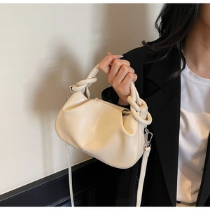 Detail of beige pleated cloud bag with knotted handle and brand logo on leather