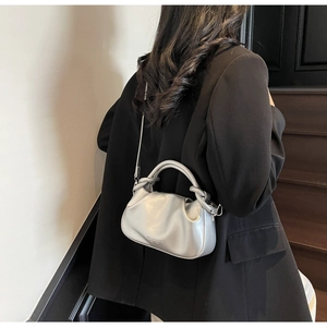 Detail view of the silver pleated cloud bag with metallic finish and adjustable strap