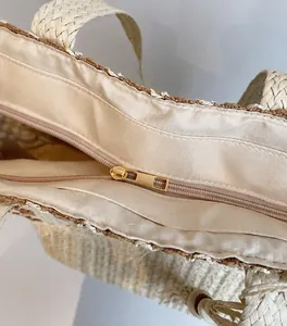 Détail de la fermeture éclair dorée et du curseur sur la doublure du sac en paille