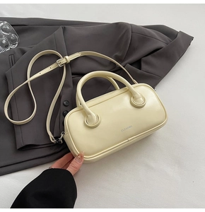 Detail of minimalist cream white handbag featuring CLEAROK branding and silver hardware