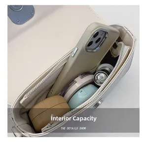 Macro view showing internal capacity of the cream crossbody bag with phone and makeup