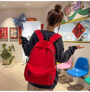 Rear view of a red high-capacity student backpack with a cover and side woven labels