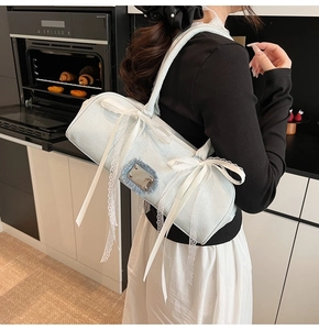 Nahaufnahme der hellblauen Denim Boston Bag mit weißer Spitze und Satin-Schleifen