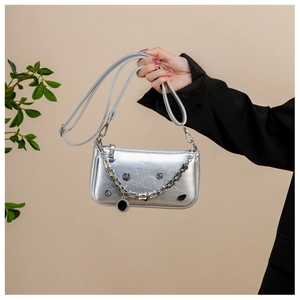 Detail of silver metallic crossbody bag with chunky chain decoration and gathered leather