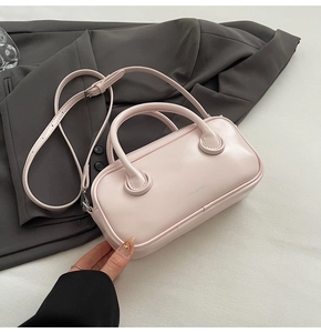 Detail view of the pink mini square bag with a polished finish and metal brand logo