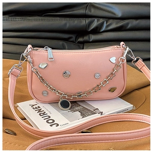 Detail of pink PU leather shoulder bag with metallic chain and heart-shaped metal accents