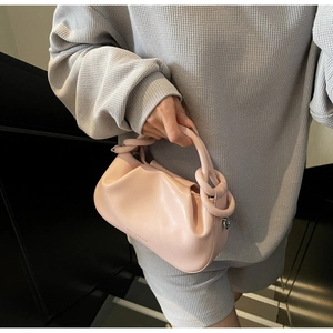 Close-up of pink ruched cloud bag with brand logo and premium matte leather texture