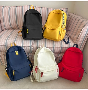 Close-up of color-block canvas backpacks in five colors with functional front zip pockets