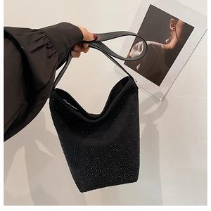 Close-up of black bucket bag featuring subtle rhinestone embellishments and leather strap