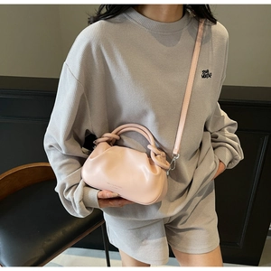 Close-up of light pink cloud bag with soft pleated leather and slim crossbody strap detail