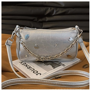 Macro shot of silver Y2K shoulder bag featuring metallic hardware and leather texture