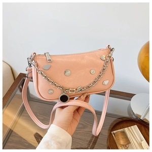 Detail of pink faux leather bag with silver heart studs and heavy metal chain strap