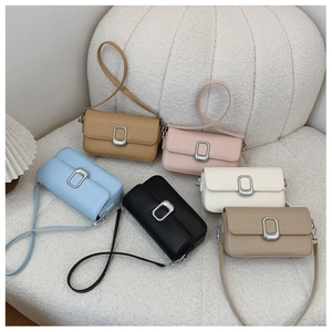 Detailed group view of colorful leather square crossbody bags with oval metal buckles