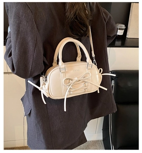 Detailed view of beige ballet-style Boston bag with decorative ribbons and bow