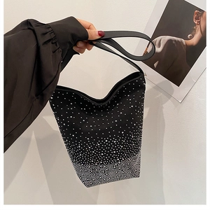 Detail view of black bucket bag with gradient silver rhinestones and leather handle