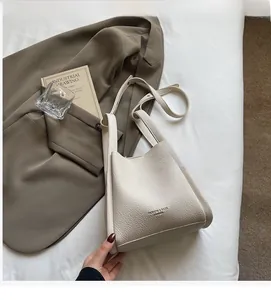 Close-up of cream lychee texture leather handbag with adjustable strap and fashion text