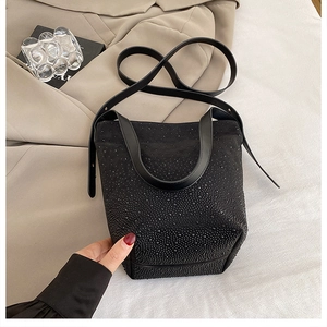 Detailed macro view of black bucket bag featuring sparkling black rhinestones and leather strap