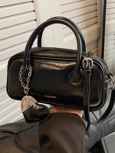 Fashionable black glossy boston handbag with heart pendant and adjustable strap