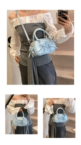 Detail of light blue metallic ballet-style Boston bag with ribbon bow and cross-lacing