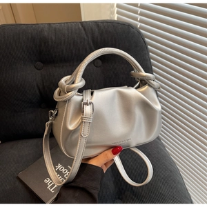 Detailed close-up of the silver pleated cloud bag with knotted handle and brand logo