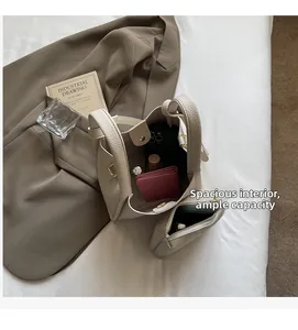 Top view of cream white leather bucket bag showing spacious interior and inner pouch