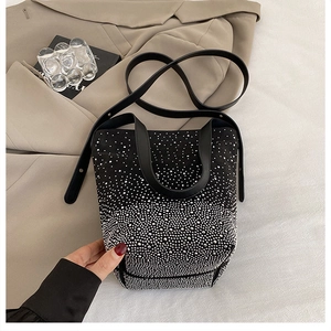 Detail of black bucket bag with gradient silver rhinestones on a khaki trench coat