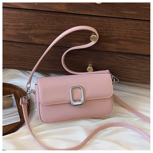 Detail of woven texture and rectangular silver metal lock on dusty pink crossbody bag