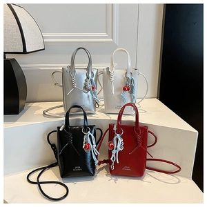 Detail of four colorful crossbody bags with leather texture and tennis racket charms