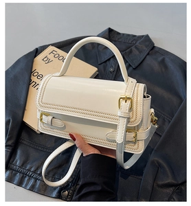 Detail of white vintage crossbody bag with gold buckles and beaded edge stitching