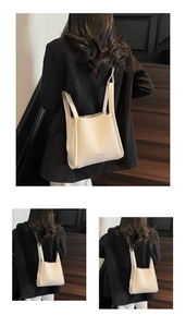 Close-up of white lychee pattern bucket bag on wooden stairs with model in black suit