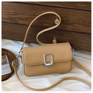 Close-up of khaki textured crossbody bag with silver oval buckle on a minimalist background